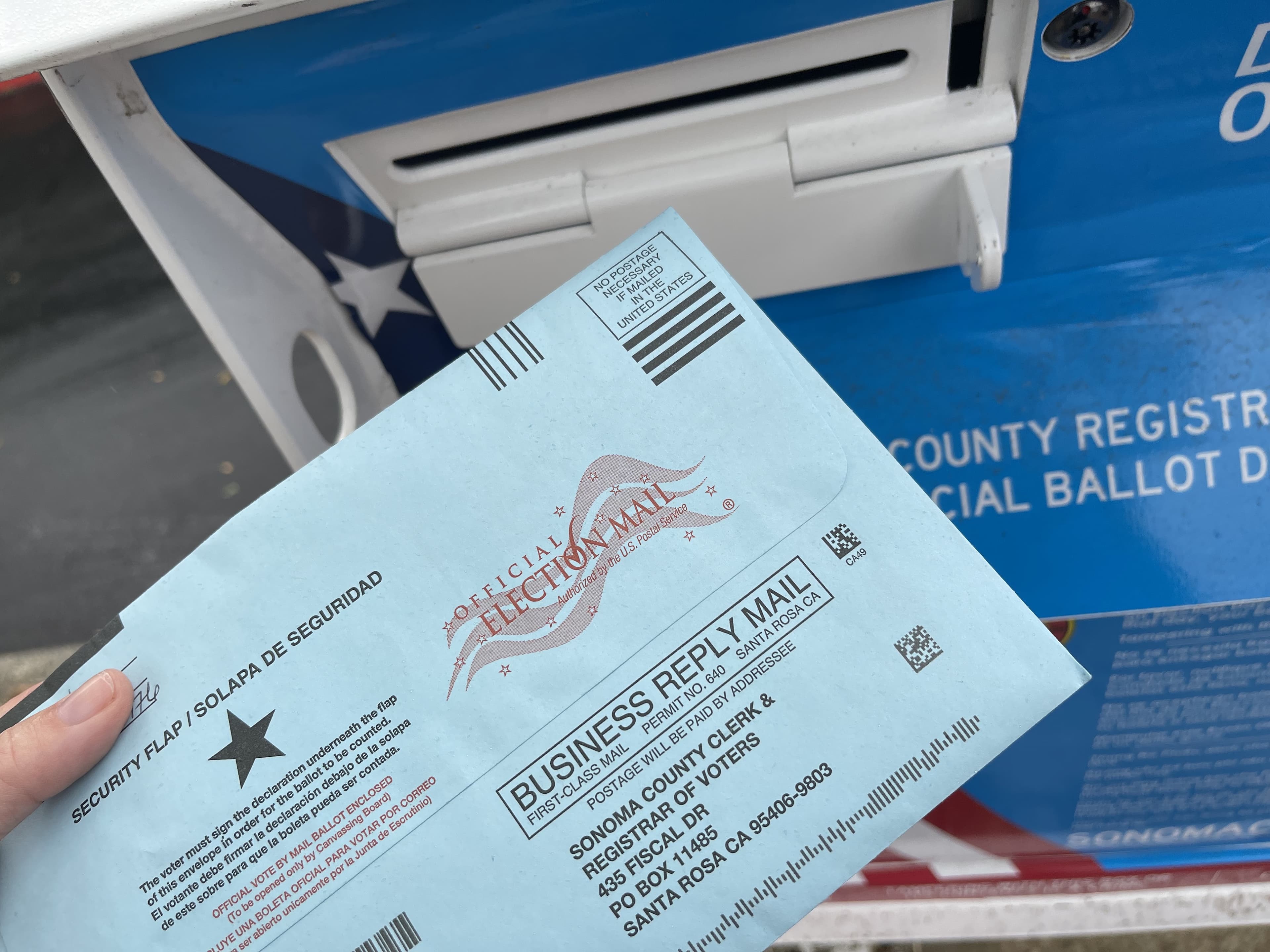 A ballot being placed into a ballot box at a polling place